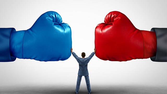 Mediate and legal mediation business concept as a businessman or person separating two boxing glove opposing competitors as an arbitration success symbol for finding common interests to lawfully solve a conflict.