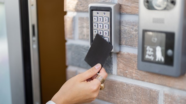 Attaching card to the electronic reader to access the office or apartment, close-up. Card entry, personal identification, keyless access, modern technologies concept